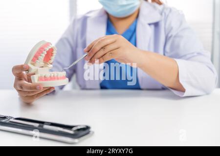 Dentista presso la clinica odontoiatrica White dente sano con modello dentale in chirurghi orali che discutono la radiografia della mascella sulla medicina tabletÂ sano Foto Stock