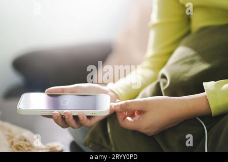 Donna mani ricarica della batteria del telefono cellulare con batteria scarica. Collegamento di un caricabatterie a uno smartphone Â con powerbank pow del power Bank Foto Stock