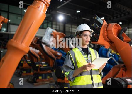 Ritratto di una donna ingegnere con la missione di controllare, testare, migliorare il software e calibrare il braccio robotico. Foto Stock