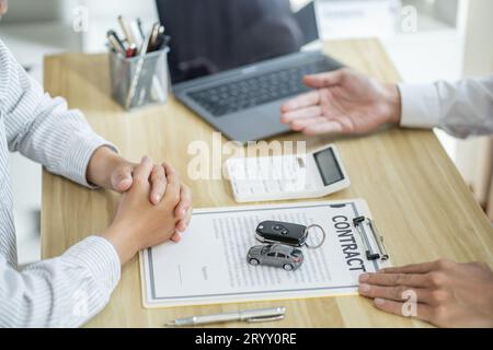 Agente assicurativo del registro delle perdite che ispeziona la vettura danneggiata. Il responsabile delle vendite fornisce un documento del modulo di richiesta di consulenza che valuta l'offerta di mutui ipotecari per auto Foto Stock