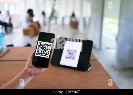 Pagamento con codice QR. Donna che esegue la scansione del codice QR per lo shopping online concetto di tecnologia cashless. Foto Stock