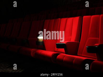 File di sedili in velluto rosso per guardare film al cinema con sfondo banner per spazi di copia. Intrattenimento e teatro. 3D. Foto Stock