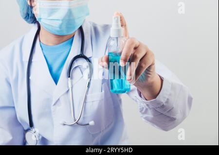 Medico spruzza disinfettante per le mani o dispenser di gel per pulire le mani e uccidere virus e batteri in aria dopo la visita dei pazienti. Foto Stock