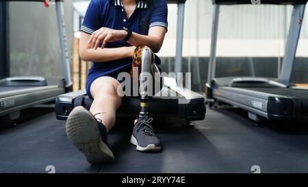 Giovane donna con una gamba protesica con la pratica di utilizzare le gambe protesiche per camminare, fare esercizio fisico e svolgere attività quotidiane Foto Stock
