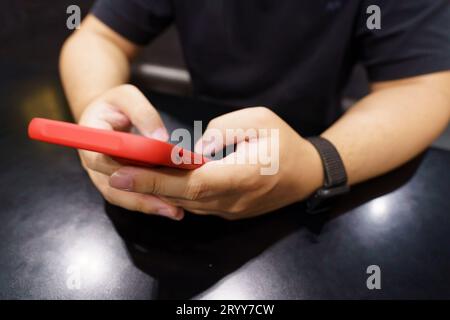 Uomo che gioca al telefono cellulare. Giocatore ragazzo che gioca ai videogiochi con smartphone che lavora con dispositivi mobili. concep. e-commerce tecnologia telefono cellulare Foto Stock