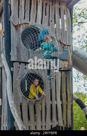 Un bambino sale su una griglia alpina in un parco giochi in una calda giornata estiva. parco giochi per bambini in un parco pubblico, entertai Foto Stock