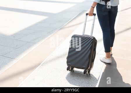 Primo piano della donna e del bagaglio del trolley in aeroporto. Concetto di persone e stili di vita. Tema viaggi e viaggi d'affari. Donna wea Foto Stock