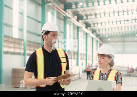 Incontro tra designer e responsabile del magazzino per organizzare la disposizione degli scaffali dei prodotti in un enorme magazzino vuoto. Foto Stock