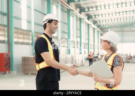 Incontro tra designer e responsabile del magazzino per organizzare la disposizione degli scaffali dei prodotti in un enorme magazzino vuoto. Foto Stock