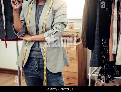 Primo piano della parte inferiore del corpo dello stilista stilista di moda in un'officina per imprenditori. Concetto su misura e cucito. Ritratto di felice casua Foto Stock