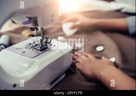 Primo piano della macchina da cucire con la sarta che disegna un nuovo sfondo in tessuto. Sarto stilista o fognatura in wor Foto Stock