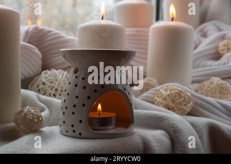 Lampada aromatica con olio essenziale, aromaterapia a casa, candela brucia, gocciolamento di olio essenziale. Concetto di relax domestico e anti Foto Stock