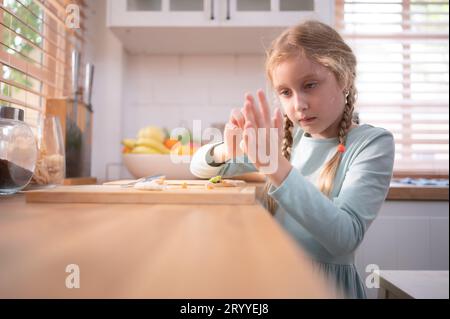 Nipote di nonni in una cucina piena di luce naturale, aiuta a cucinare la cena per la giornata per la famiglia. Foto Stock