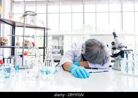 Esaurito scienziato dormire in laboratorio. La gente di stili di vita e di occupazione del concetto. La scienza e l'esperimento in tema di laboratorio. Foto Stock