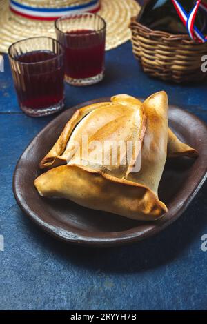 Empanadas de pino y napolitano al forno cileno su piatti di argilla con vino. Piatto e bevande il 18 settembre festa indipendenza Foto Stock