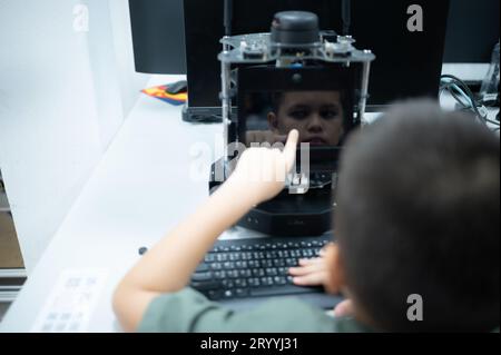 I giovani che utilizzano la tecnologia del robot manuale si divertono a imparare il circuito stampato elettronico e il controller del robot manuale della tecnologia robot, whi Foto Stock