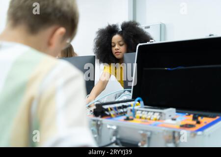 I giovani che utilizzano la tecnologia del robot manuale si divertono a imparare il circuito stampato elettronico e il controller del robot manuale di Foto Stock