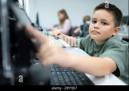 I giovani che utilizzano la tecnologia del robot manuale si divertono a imparare il circuito stampato elettronico e il controller del robot manuale di Foto Stock