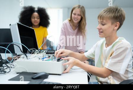 I giovani che utilizzano la tecnologia del robot manuale si divertono a imparare il circuito stampato elettronico e il controller del robot manuale della tecnologia robot, whi Foto Stock