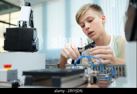 I giovani che utilizzano la tecnologia del robot manuale si divertono a imparare il controller del robot manuale della tecnologia robotica, che è o Foto Stock