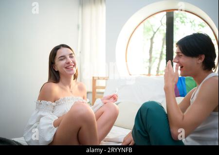 L'amicizia nel recuperare le differenze. da un'amica donna che mette rossetto su un amico gay Foto Stock