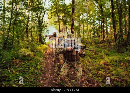 Un gruppo di moderni soldati di guerra sta combattendo una guerra in aree boschive remote e pericolose. Un gruppo di soldati sta combattendo contro l'en Foto Stock
