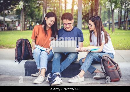 Tre giovani studenti asiatici del campus amano fare lezioni e leggere libri insieme. Concetto di amicizia e istruzione. Scuola universitaria e. Foto Stock