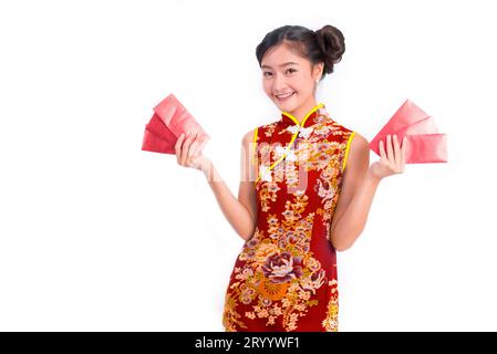 Giovane donna asiatica di bellezza che indossa cheongsam e porta con sé un pacchetto di soldi rosso in occasione del festival cinese di Capodanno su un isolato ba bianca Foto Stock