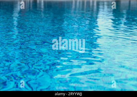 Acqua della piscina astratta. La piscina scorre con onde che fanno da sfondo alla piscina blu Foto Stock