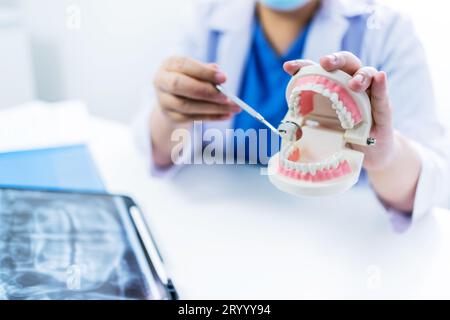 Dentista presso la clinica odontoiatrica White dente sano con modello dentale in chirurghi orali che discutono la radiografia della mascella sulla medicina tabletÂ sano Foto Stock