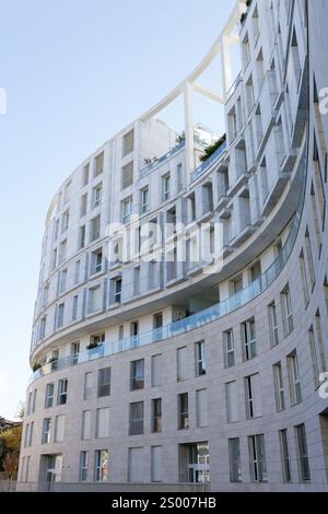 Moderno edificio architettonico curvilineo con luce fredda del sole Foto Stock