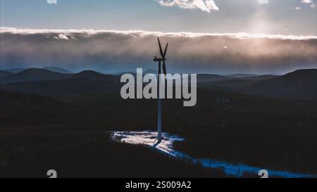 Turbina eolica solitaria con nuvole di tempesta in inverno nel Maine Foto Stock