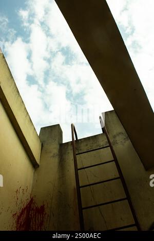Una scala intemprata si estende verso l'alto dalle ombre, penetrando nell'oscurità verso l'abbraccio radioso del cielo aperto, un viaggio dalla disperazione Foto Stock