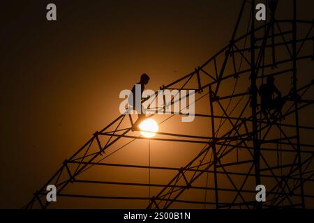 Prayagraj, India. 22 dicembre 2024. I laburisti preparano una tenda, prima del festival Maha Kumbh Mela, a Sangam, il punto d'incontro dei fiumi Gange, Yamuna e Saraswati leggendari a Prayagraj. È in corso la costruzione di una città temporanea intorno alla confluenza sacra dei fiumi più sacri dell'India, per la più grande assemblea della storia mondiale. Credito: SOPA Images Limited/Alamy Live News Foto Stock