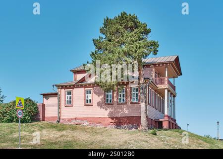 Sviyazhsk, Russia - 12 giugno 2024: Storica casa tradizionale in legno di Trotsky . Dettagli ornamentali, balcone, colonne, tetto spiovente. Atmosfera rurale. Foto Stock