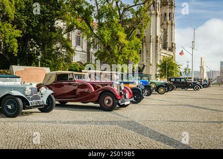 Lisbona, Portogallo - 15 ottobre 2023: Fila di auto classiche o pre-belliche vicino a un edificio storico su strada acciottolata nelle giornate di sole durante il Meetup dei proprietari di auto classiche con Aston Martin 15-98, Lagonda LG45, Ford A Phaeton, Chevrolet AC International e altri Foto Stock