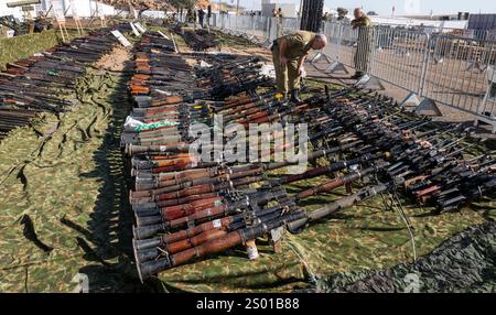 Amirim, Israele. 23 dicembre 2024. Un soldato israeliano guarda alcune delle centinaia di fucili d'assalto leggeri e RPG (Rocket Propelled Granades) sequestrati alle forze di Hezbollah in mostra in una base dell'esercito israeliano non lontano dal confine con il Libano meridionale il 23 dicembre 2024. L'IDF mise in mostra circa 86.000 oggetti che hanno catturato nel sud del Libano, a sud del fiume Litani, durante i combattimenti contro le forze di Hezbollah che iniziarono Octobert 1, 2024. Foto di Jim Hollander/UPI credito: UPI/Alamy Live News Foto Stock