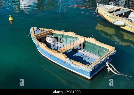 Vecchia barca da pesca a Marsaxlokk, Malta, con scritta Titanic sul sedile Foto Stock