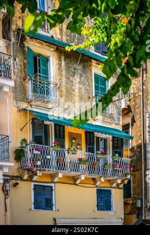 Una vista panoramica di un antico edificio adornato da vibranti decorazioni floreali sul suo balcone. Foto Stock