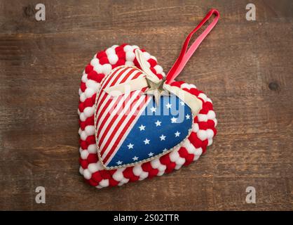 Bandiera USA con forma a cuore in tessuto a strisce su vecchio sfondo in legno Foto Stock