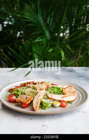 Presentata su una tavola rotonda rustica in legno, questa Caesar Salad crea un contrasto visivo sorprendente tra gli ingredienti classici e quelli moderni Foto Stock