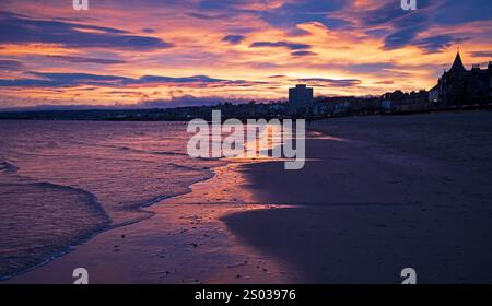 Portobello, Edimburgo, Scozia, Regno Unito. 24 dicembre 2024. Moody warm Sunrise by the Firth of Forth per la vigilia di Natale, temperatura 12 gradi centigradi. Un colorato cielo dell'alba illumina la tranquilla spiaggia di sabbia credito: Notizie dal vivo Archwhite/alamy. Foto Stock