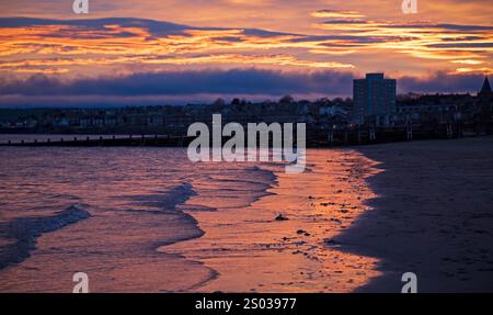 Portobello, Edimburgo, Scozia, Regno Unito. 24 dicembre 2024. Moody warm Sunrise by the Firth of Forth per la vigilia di Natale, temperatura 12 gradi centigradi. Un colorato cielo dell'alba illumina la tranquilla spiaggia di sabbia credito: Notizie dal vivo Archwhite/alamy. Foto Stock
