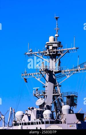 Una grande nave con un albero alto e un cielo blu sullo sfondo. Il montante è coperto da fili e antenne Foto Stock