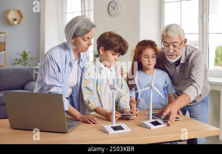 Nonni che mostrano ai bambini un modello di turbina eolica, da vicino Foto Stock
