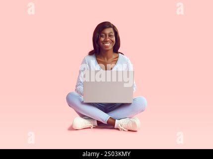 Donna afroamericana che lavora online con un laptop che celebra il profitto, il reddito degli investimenti Foto Stock