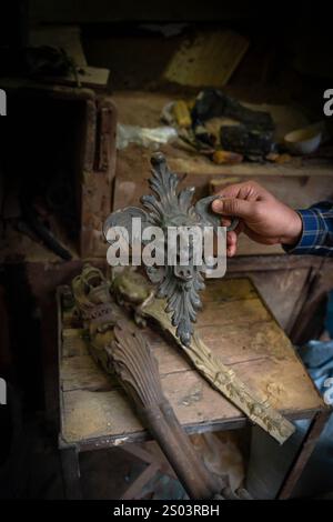 Un dettaglio di artigianato in bronzo, sapientemente fatto a mano in un laboratorio di strada di Alessandria, Egitto. La mano dell'artigiano mette in risalto l'intricata maestria artigianale. Foto Stock
