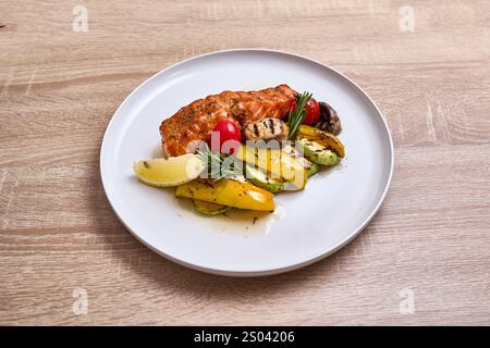 Filetto di salmone grigliato servito con verdure arrostite e spicchio di limone. Foto Stock