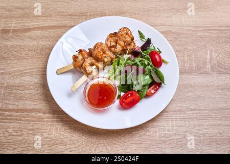 Spiedini di gamberi grigliati serviti con insalata fresca e salsa al peperoncino dolce. Foto Stock