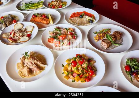 Un tavolo splendidamente organizzato con una selezione di piatti gourmet, che mostrano la diversità del menu di un ristorante. Foto Stock